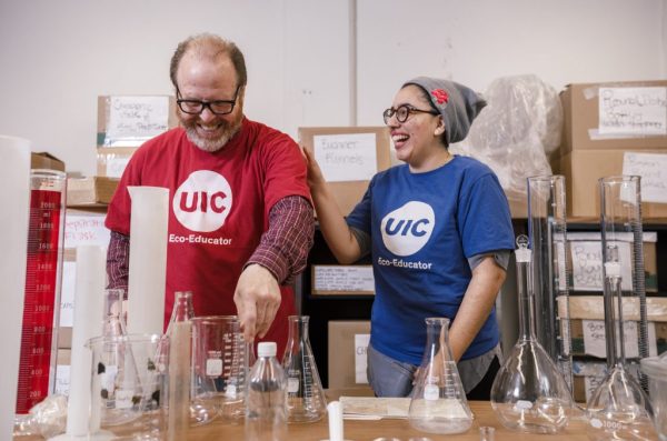 Two people wearing UIC shirts in a lab.