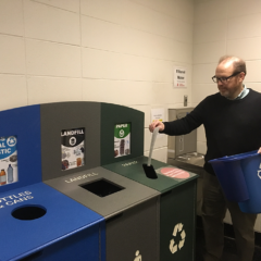 UIC Staff empties his desk-side recycling bin into the larger hallway bin