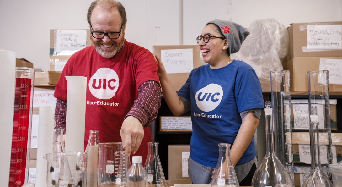 Two people in UIC t-shirts working in a lab