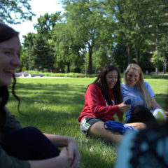 Students sitting on campus lawn