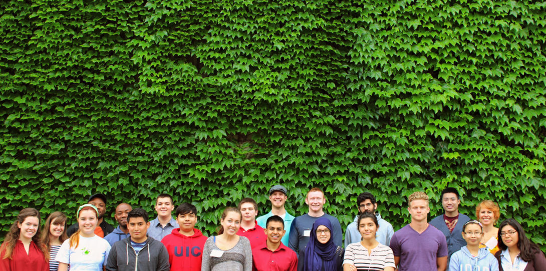 Students standing in front of a wall of green ivy