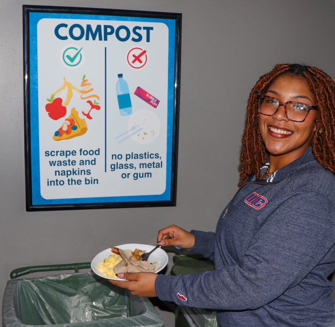 Student composting food scraps